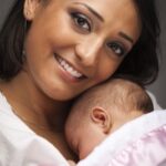 Young Attractive Ethnic Woman Holding Her Newborn